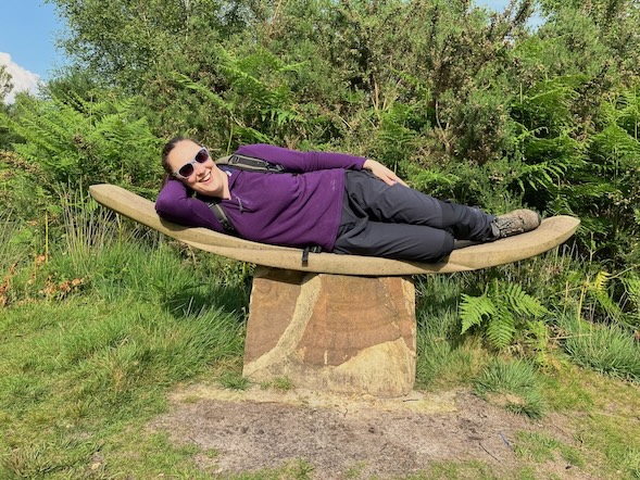 Sian lying down on a stone bench